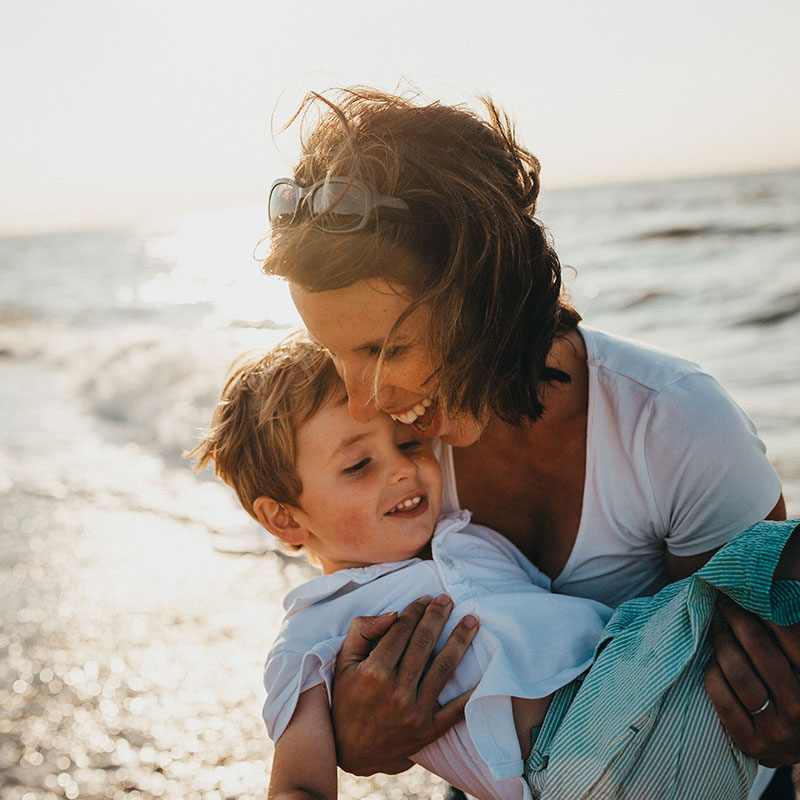 Mom and kid playing on the beach | Pressure Wave Therapy in Hampstead, NC | Hampstead Chiropractic